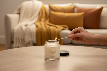 warm ,cozy livingroom setting sitting atop a liv ngroom table with someone lighting the candle